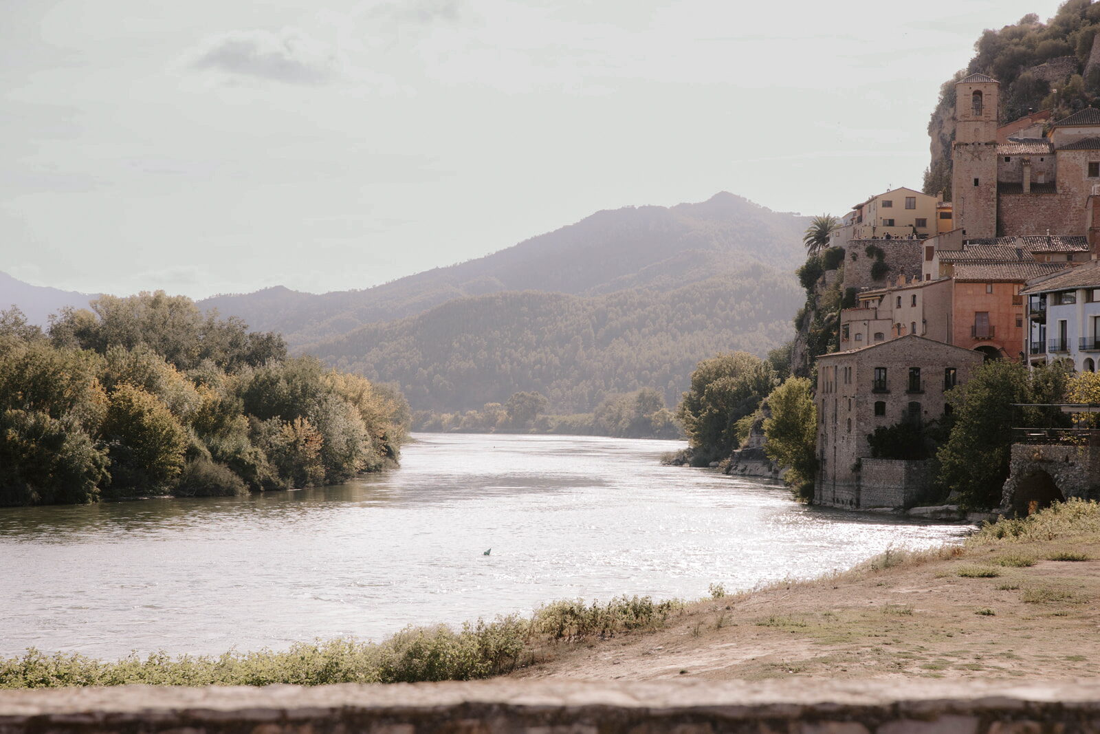 Poble de Miravet enfilat sobre el riu Ebre entre muntanyes boscoses