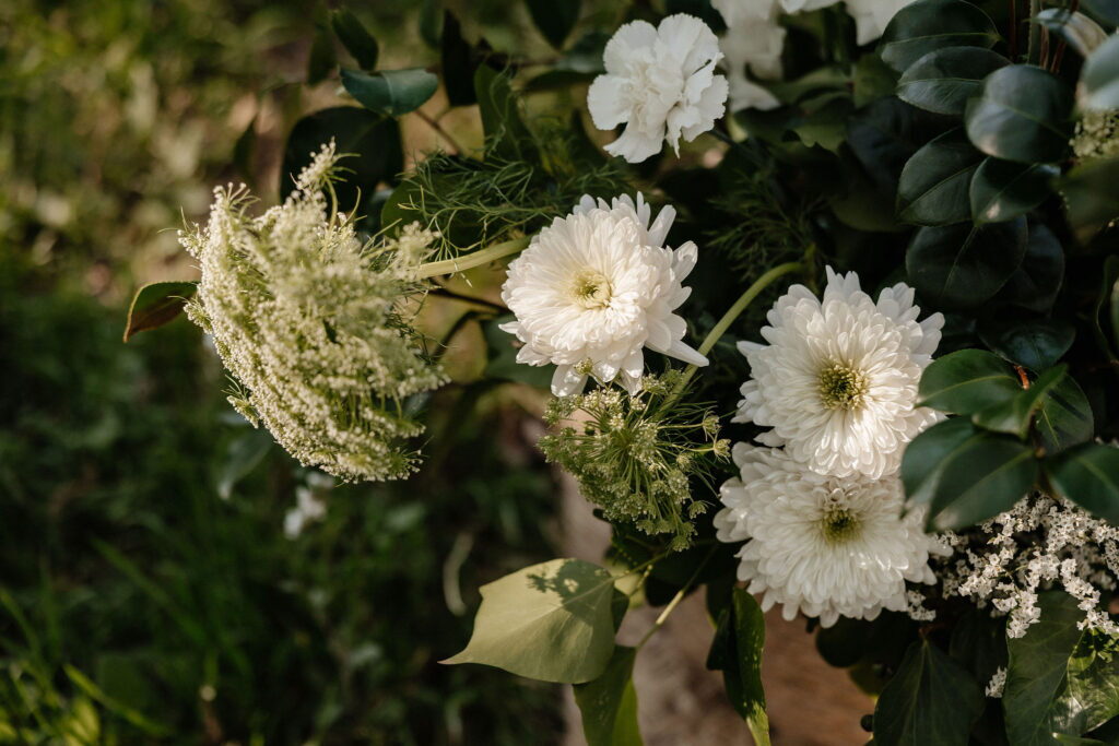 Detall de composició floral blanca amb crisantems i vegetació