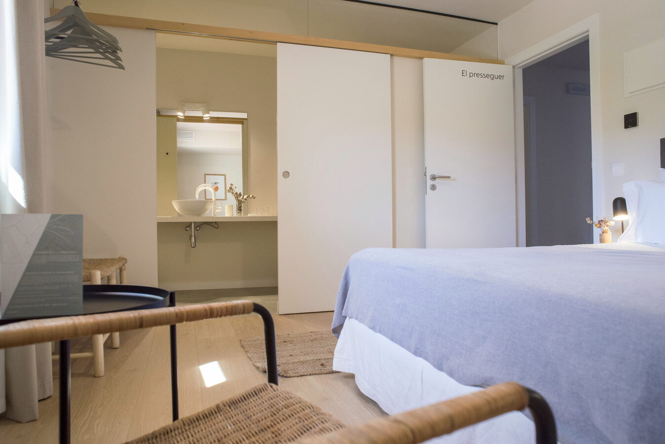Habitació El Presseguer amb llit, lavabo obert i porta retolada