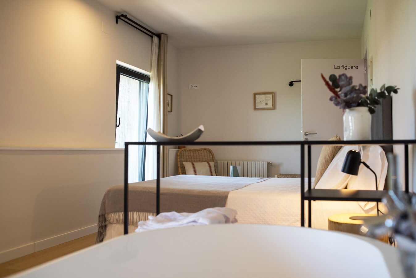 Habitació La Figuera amb banyera exempta i llit al fons