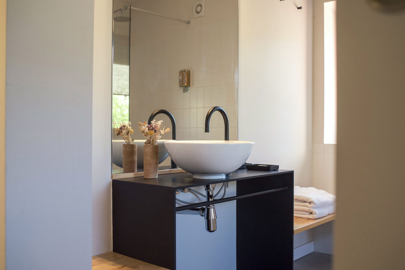 Bany de l'habitació amb lavabo de sobreencimera, mirall i tovalloles