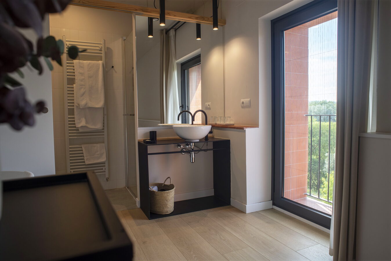 Bany amb lavabo, tovalloles i finestra amb vistes al camp