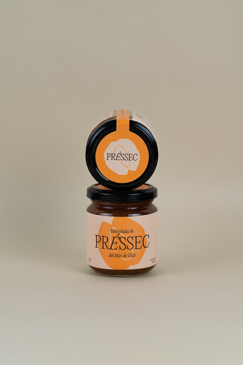 Dos pots de melmelada de préssec apilats amb etiqueta taronja