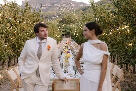 Nuvis vestits de blanc entre els fruiters amb llumetes de festa